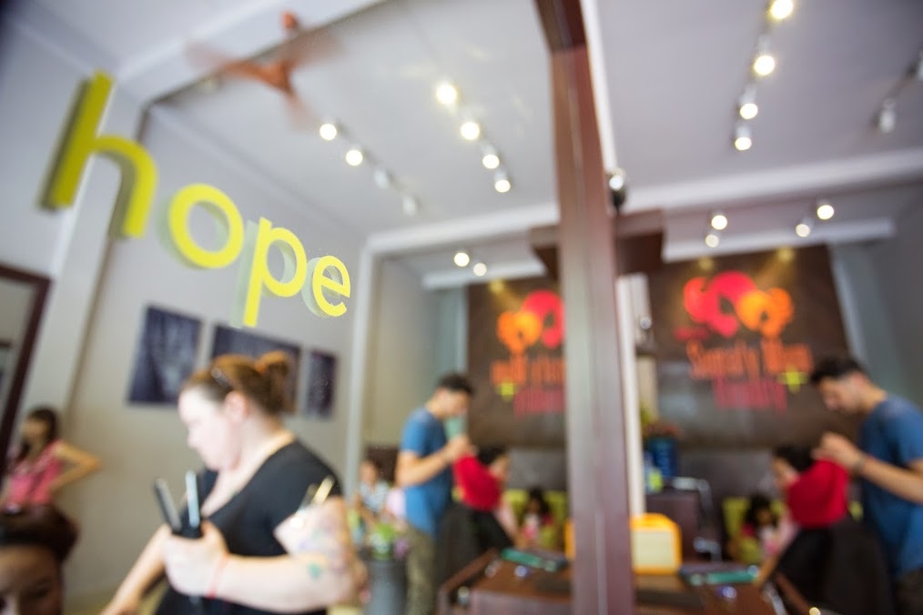 Blurry image of a Beauty Plus salon with the word hope visible in the mirror